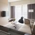 Jolley Hotel Taipei City room with sofa, wall TV, round coffee table, and city-view window drapes