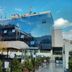 Hotel Art Sarajevo with a mirrored glass facade, courtyard greenery, and mountain reflections