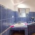 Hotel Laguna del Cocodrilo bathroom in Tamarindo with blue tile, sink, toilet and towel art