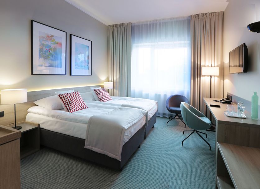 Hotel Fairplayce Poznan guest room with twin beds, desk, chairs, and large window
