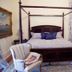 Dansereau House in Thibodaux bedroom with four-poster bed, armchair, curtains and hardwood floor