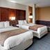 Comfort Suites Texarkana guest room with two beds and a sofa seating area