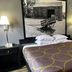 Super 8 by Wyndham Mound City guest room with king bed, bedside lamps, and framed black-and-white wall art