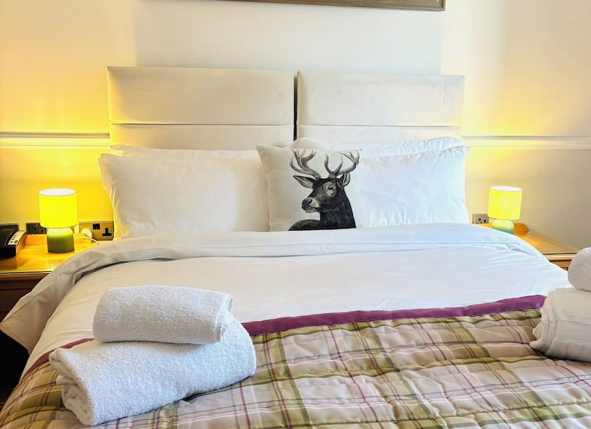 Little Silver Country Hotel in Tenterden bedroom with neatly made bed, bedside lamps and folded towels