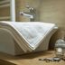 Oliva Hotel in Veszprém bathroom with folded towels, sink, toiletries and soap dispenser