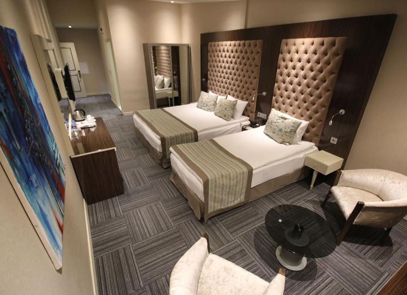 Ankara Gold Hotel in Ankara room with two twin beds, tufted headboards, armchair and table