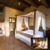 Agriturismo Il Casale Degli Amici in Norcia: rustic bedroom with four-poster bed and stone fireplace