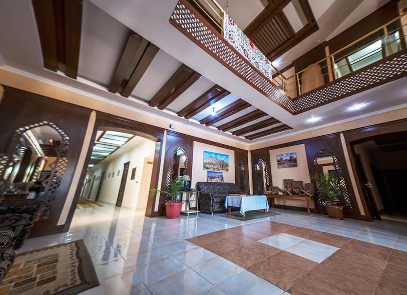 Arkanchi Hotel Khiva lobby with tiled floor, arched doorways, mezzanine balcony and seating