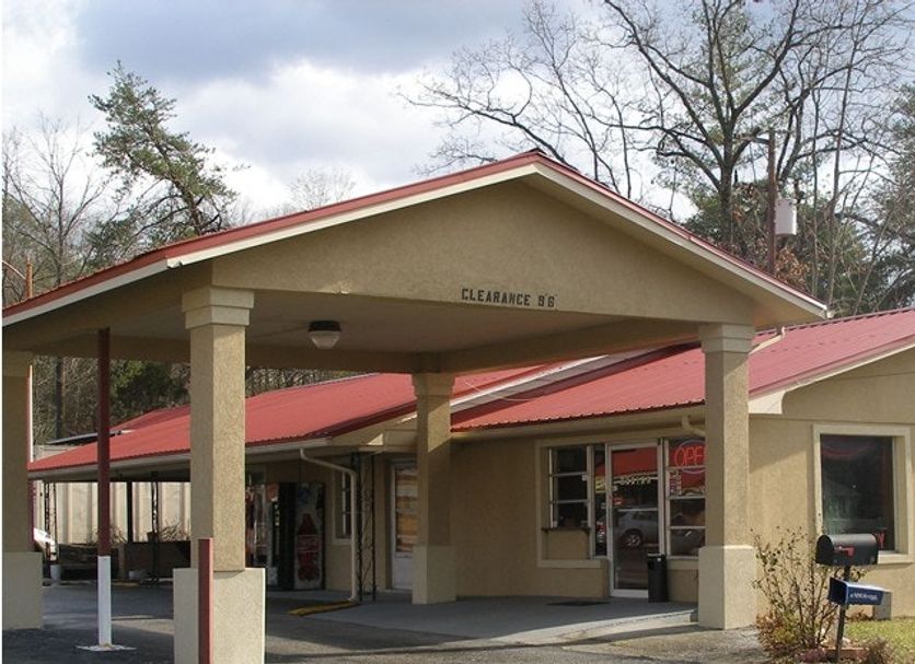 Executive Inn in Rocky Top with a covered driveway and beige entrance under a red roof