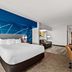 Comfort Inn & Suites Donna guest room with king bed, sofa seating and modern blue accent wall