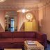 Ignacia Guest House in Mexico City lounge with burgundy sofa, gold cabinets and ornate ceiling