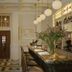 Château Voltaire Paris bar with marble counter, hanging globe lights, and flower arrangement