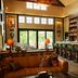 Berkshires Untold in Lenox: warm lounge with leather seating, bar stools, and large windows overlooking greenery.