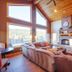 Zion Ponderosa Ranch Resort in Mount Carmel living room with large windows, stone fireplace and mountain views