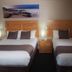 Dongara Hotel Motel in Dongara room with two twin beds, bedside lamps, and framed coastal wall art
