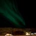 Vallakot Farm Guesthouse in Laugar under green northern lights above a dark rural landscape