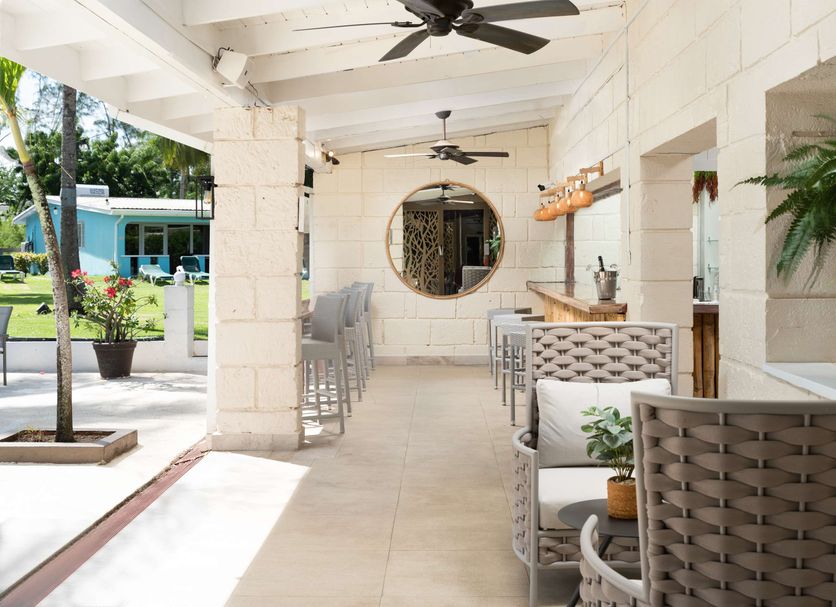 All Seasons Resort - Europa Holetown open-air hotel bar and seating area with garden view