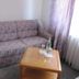 Hotel Am Markt in Eckartsberga: floral sofa beside a wooden coffee table near a curtained window