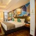 Hotel Jagjeet, Darjeeling guest room with king bed, geometric accent wall, desk, and large window