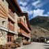 Hostal la Font in Os de Civís, stone alpine hotel with wooden balconies and mountain backdrop