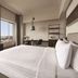 Shangri-la Surabaya guest room with city views, king bed, desk, and seating area in Surabaya