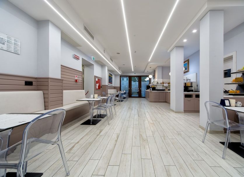Hotel Giotto in Padua lobby lounge with tables, chairs, reception desk and bright modern interior