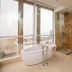 The Landmark Hotel in Baku bathroom with freestanding tub, glass shower and city view