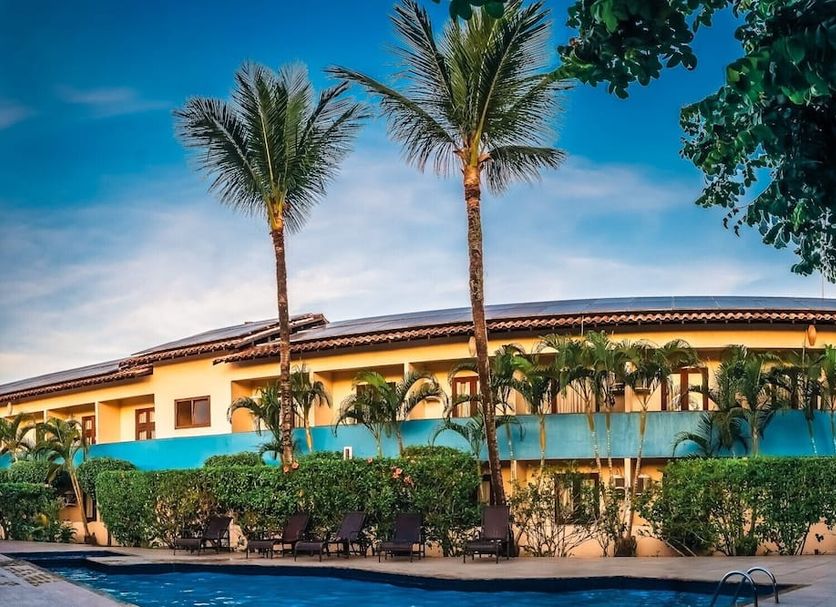 Ayla Praia Hotel in Porto Seguro with palm trees and a turquoise pool beside the building