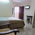 Skudai Baru Hotel room in Skudai with bed, chair, desk, wall-mounted TV and open door