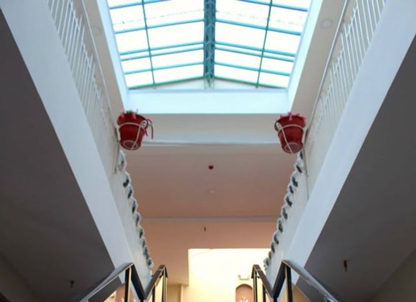 Hotel Norte in Cuenca: grand indoor staircase with red carpet leading to a skylit atrium