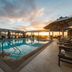 Pestana Rio Atlântica rooftop pool at sunset with lounge chairs and ocean view in Rio de Janeiro