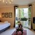 Le Manoir de Gressy guest room with twin bed, balcony doors to garden view, and TV in Gressy