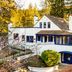 The Stavrand Russian River Valley in Guerneville, white hillside hotel with blue-trimmed windows and forest backdrop