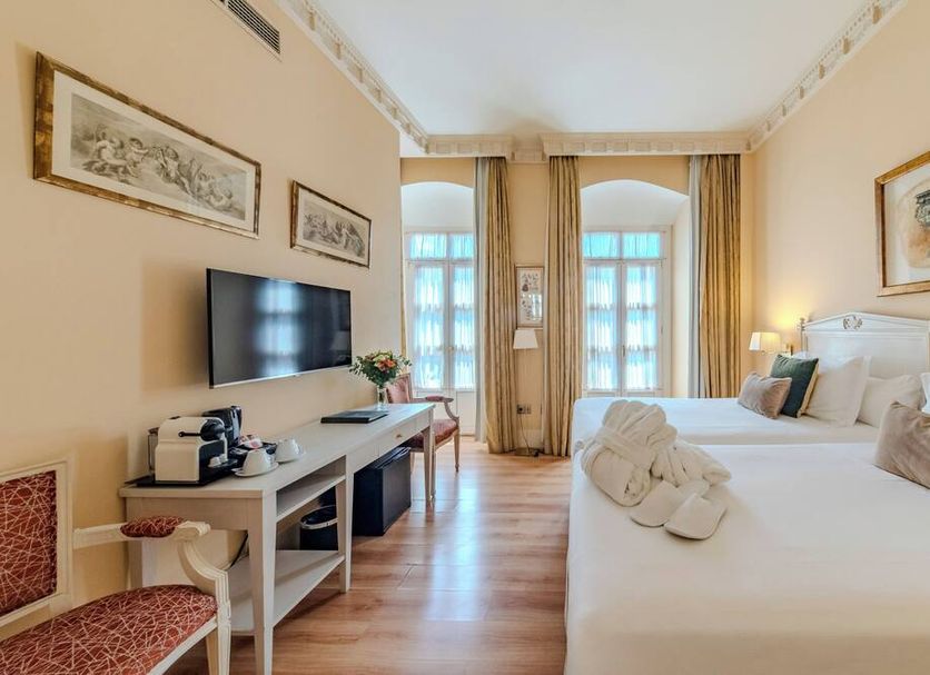 Casa Romana Hotel Boutique, Seville: bright twin room with TV, desk, and tall windows with curtains