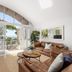 Noosa Outrigger Beach Resort in Noosa Heads living room with leather sofas, TV, and balcony ocean view