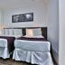 San Diego Suites Pampulha Hotel in Belo Horizonte, twin beds in a simple guest room with white curtains