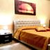 I Faraglioni in Terrasini bedroom with upholstered bed, bedside lamps and sunset wall art