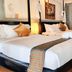 Nataya Round House Coral Bay Resort in Kampot guest room with two four-poster beds and wood floors