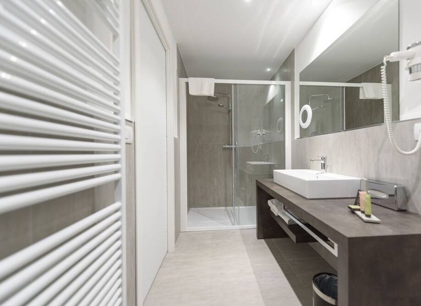 Bella Hotel & Restaurant bathroom with walk-in shower, vanity sink, and wall mirror in San Felice del Benaco