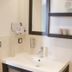 Auberge de la Baie in Pontorson bathroom vanity with sink, mirror, wall-mounted shelves and hair dryer