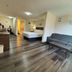 Inn at the Sea in Long Beach hotel room with bed, gray sofa, and wood-look flooring