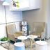 Home Inn Dalian Jinzhou Railway Station Stadium lounge with armchairs, small tables, and a potted plant