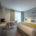 Maldron Hotel Manchester City Centre guest room with king bed, yellow accents, and city-view window in Manchester