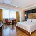GH Galeria hotel room in Guayaquil with king bed, wood flooring, and a window-side sitting area