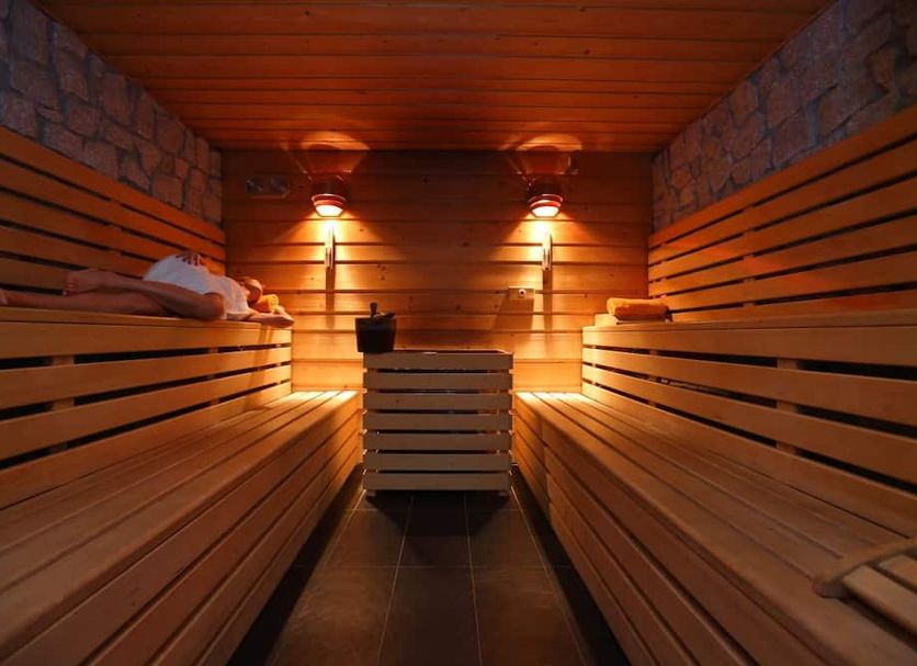 Grand Hotel Miramonti sauna in Passo del Tonale with wooden benches and warm wall lighting