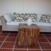 Karibu Aruba in Noord lounge with wicker sofa, patterned cushions and rustic wood coffee table