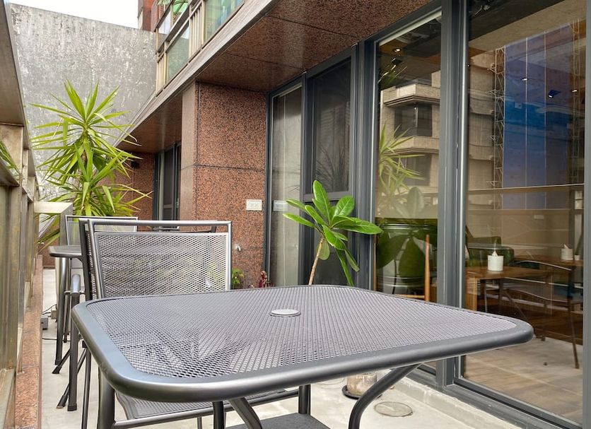 We Come Hostel Taipei City outdoor patio with table, chairs, potted plants and sliding glass doors