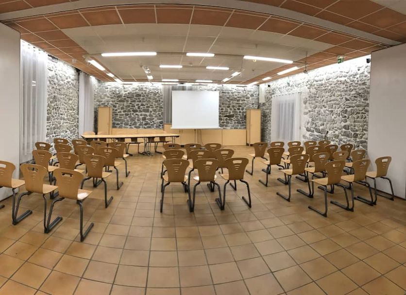 Auberge de la Vallée d'Ossau in Bielle meeting room with rows of chairs facing a projector screen