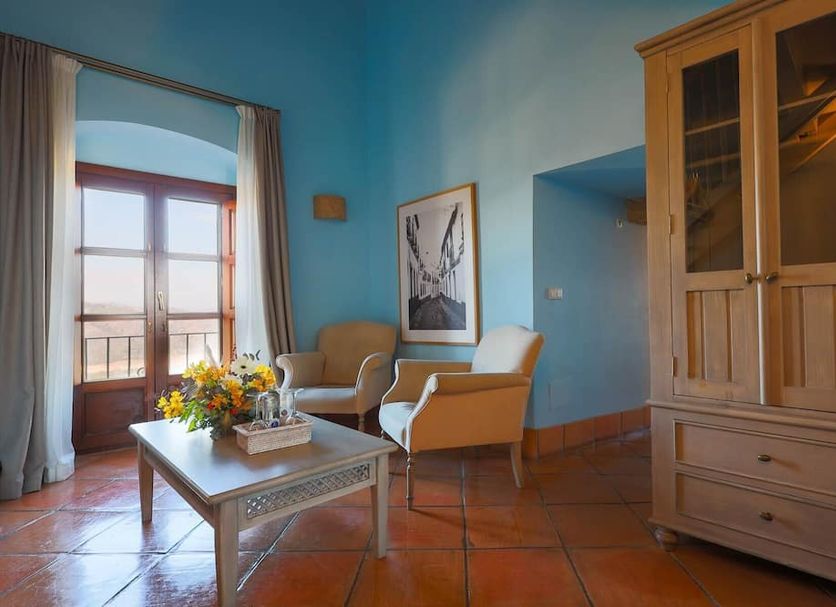 Tugasa Castillo De Castellar room with balcony door, seating area, and wooden cabinet in Castellar de la Frontera