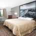 Super 8 by Wyndham Miles City guest room with bed, desk, TV, window and armchair